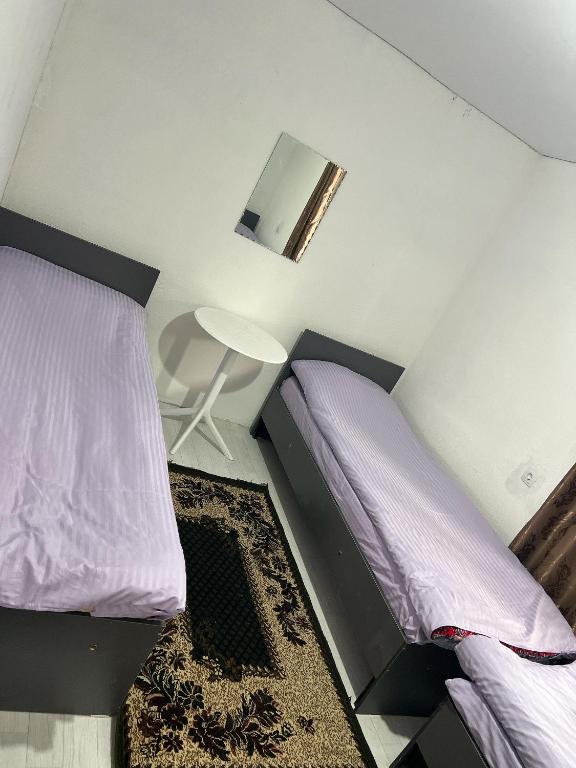 a bedroom with a bed with purple sheets and a lamp at Байэл хаус in Bosteri