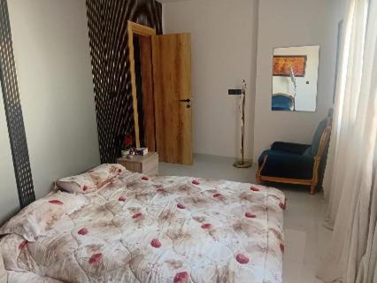 a bedroom with a bed and a blue chair at Comme chez vous in Dakar