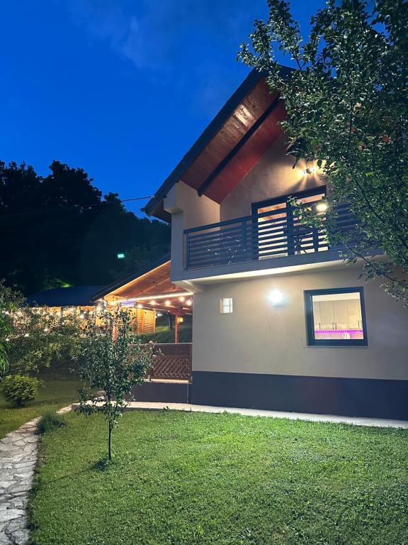 a house with a balcony at night at Villa Lux Nature in Sarajevo