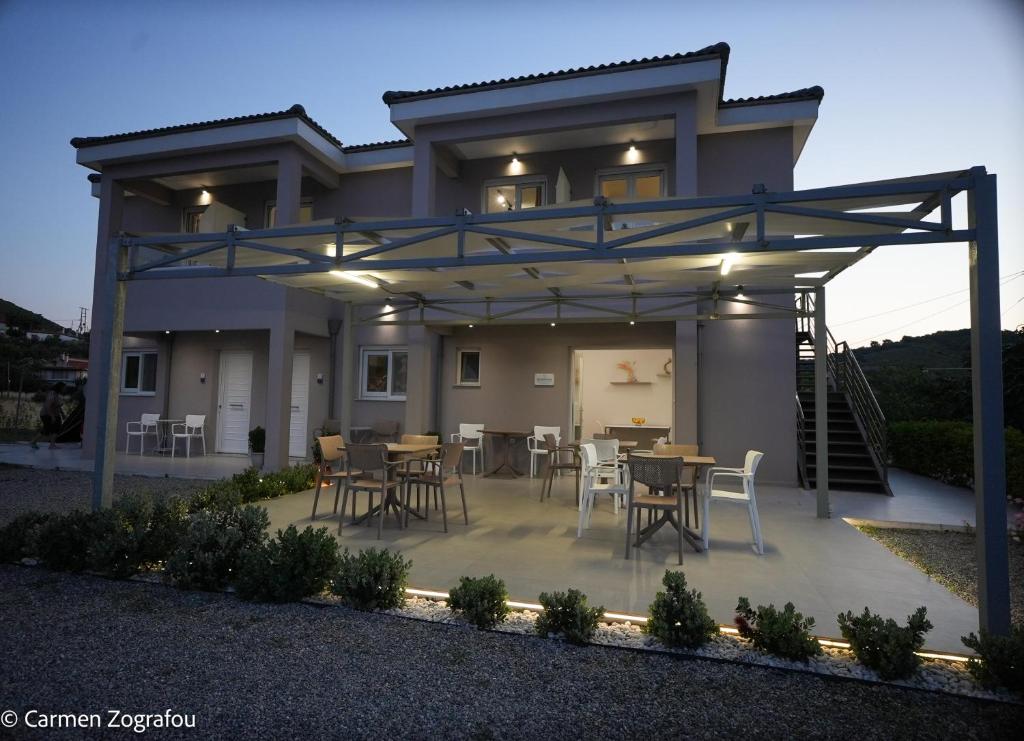 a house with a patio with tables and chairs at Costa Varda Apartments in Mourteri