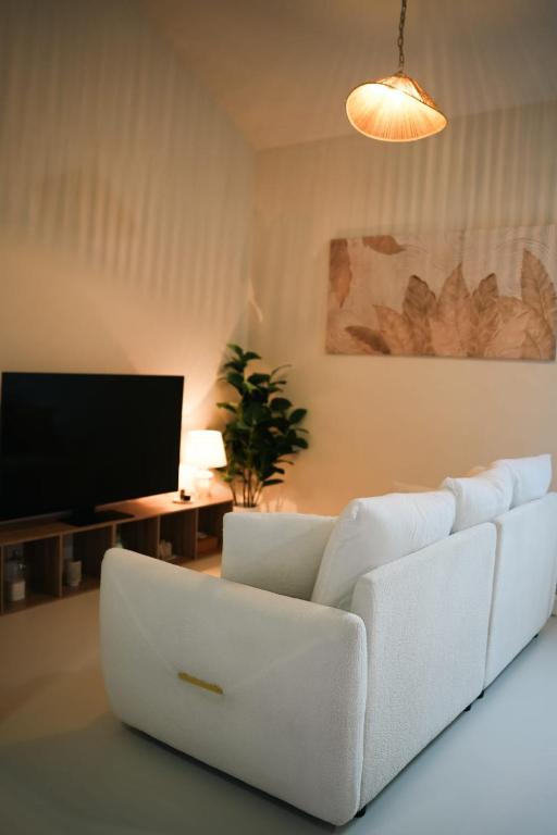 a living room with a white couch and a tv at Villa Zen - 1 Bedroom Studio in Saint James
