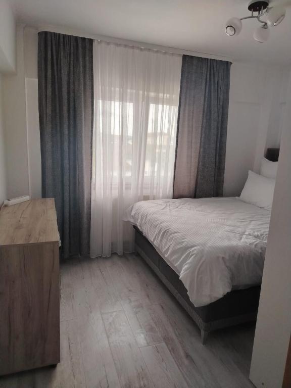 a small bedroom with a bed and a window at Apartament OAȘUL 2 in Hurez