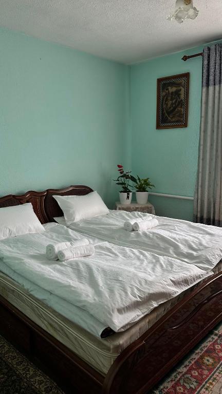 a large bed in a bedroom with blue walls at datkaguesthouse in Kochkorka