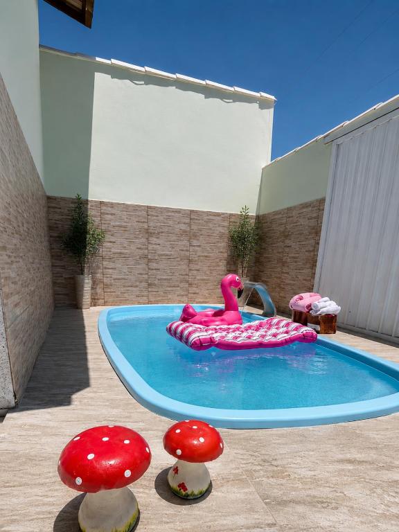 a swimming pool with a pink flamingo and mushrooms at Casa com Piscina Privativa e Área Gourmet in Rio das Ostras