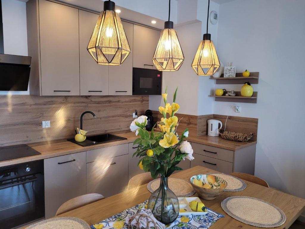 eine Küche mit einem Tisch, auf dem eine Blumenvase steht in der Unterkunft Apartament LILLA 2 in Jelenia Góra