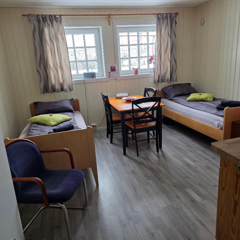 a room with two beds and a table and chairs at Valdres, sykkelturer - fisking - overnatte på vei øst vest RV51, 2 pers - eget bad, Rom nr 2 in Tisleidalen