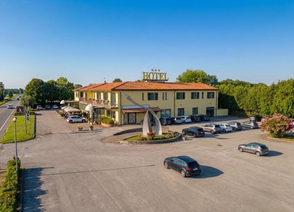 ein Parkplatz mit Autos vor einem Hotel in der Unterkunft GRAN DELTA River & Nature Hotel in Rosolina