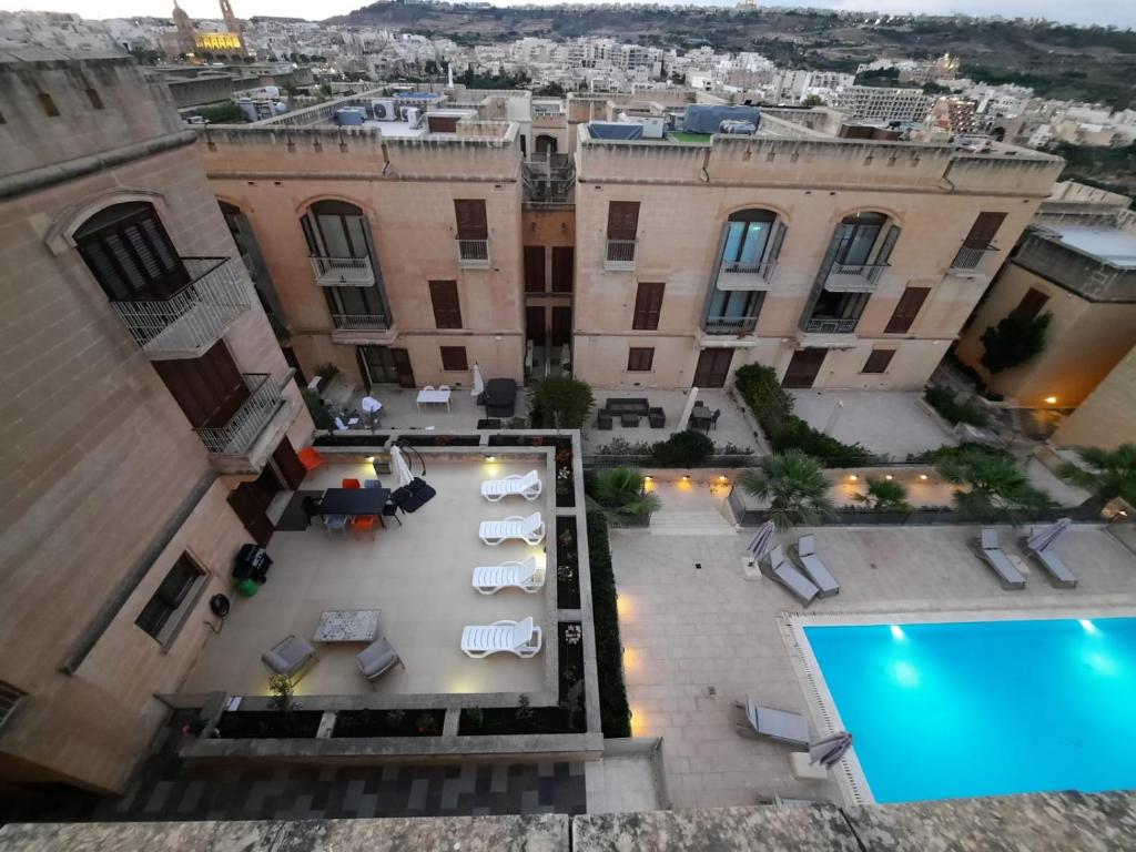 a view of the courtyard of a building with a pool at Spacious Poolside Apartment with Patio 11A2S in Għajnsielem