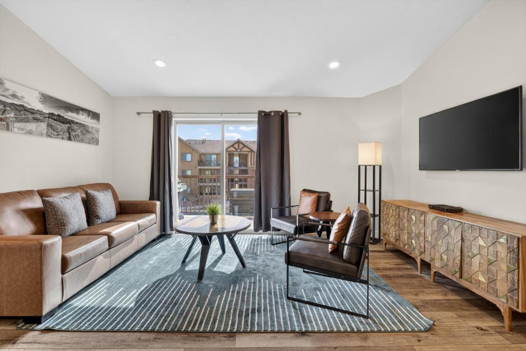 a living room with a couch and a tv at Moab Redcliff Condos in Moab