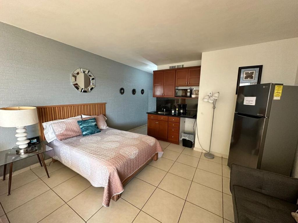 a bedroom with a bed and a refrigerator at By the sea Condominium in San Carlos