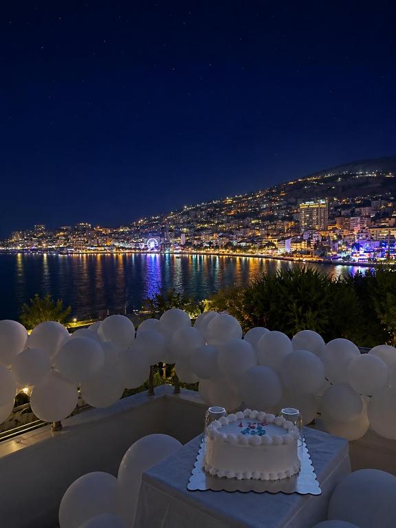 a cake on a table with a view of the water at Hotel Barjami in Sarandë