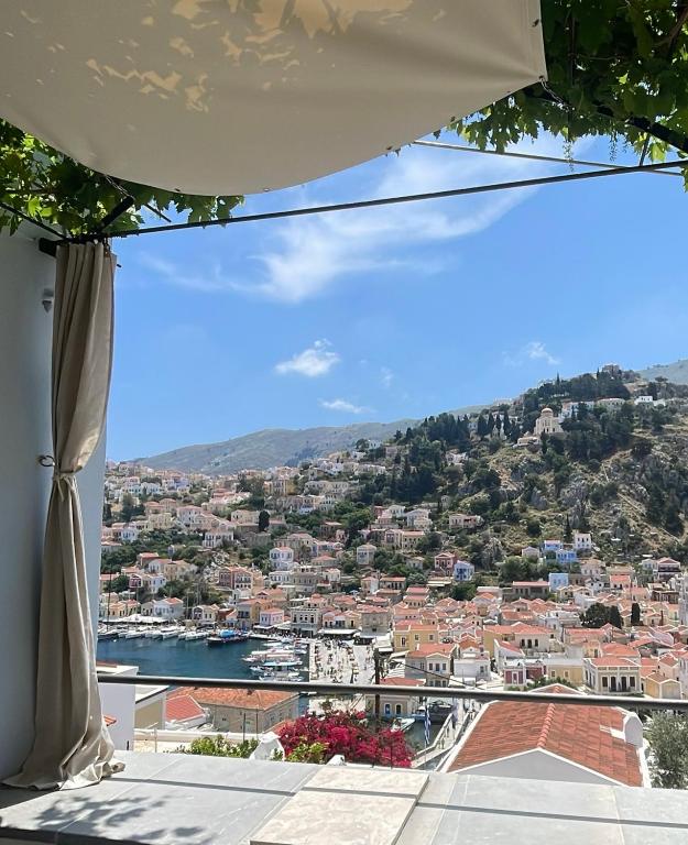 a view of a city from a balcony at kalosymi house, traditionelles haus mit hafenblick in Symi