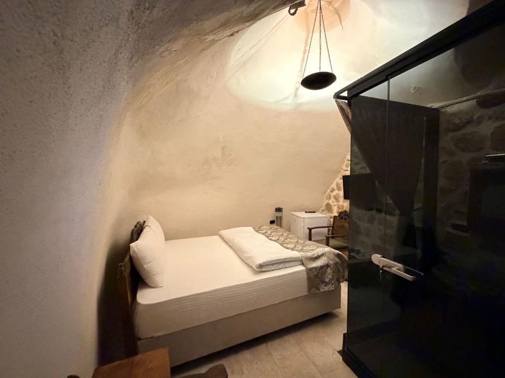 a small bedroom with a bed in a room at Mirisso Konağı MARDİN in Mardin