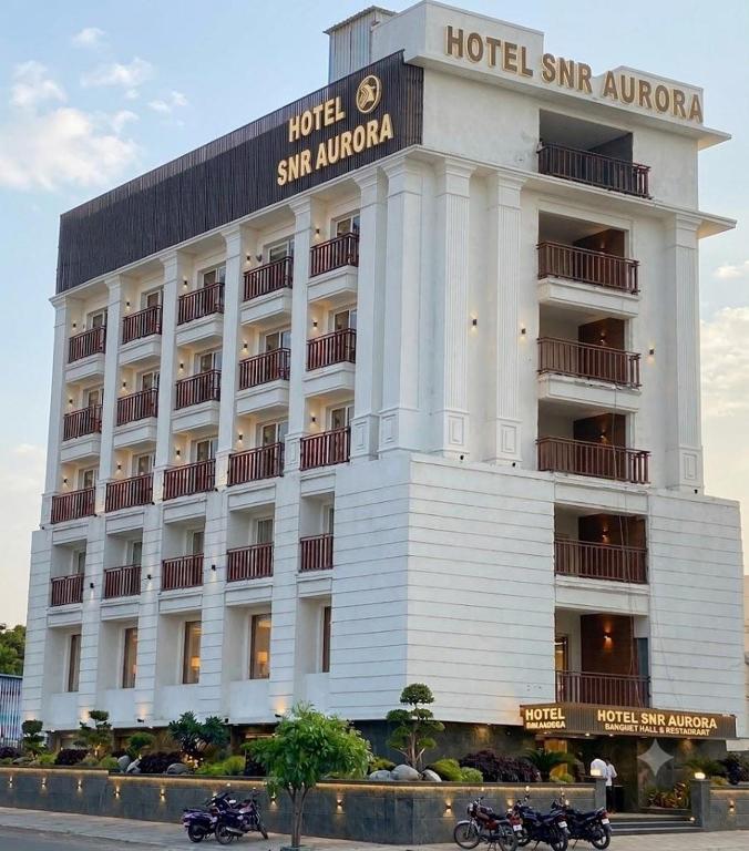 a hotel with motorcycles parked in front of it at HOTEL SNR AURORa in Guntūr