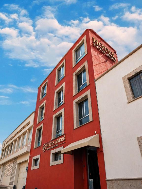 a red building with a sign on it at Suites André Confort Ejecutivo in Aguascalientes