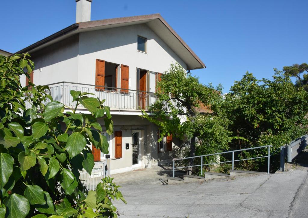 a white house with a balcony on the side at Casa Argi in Camerano