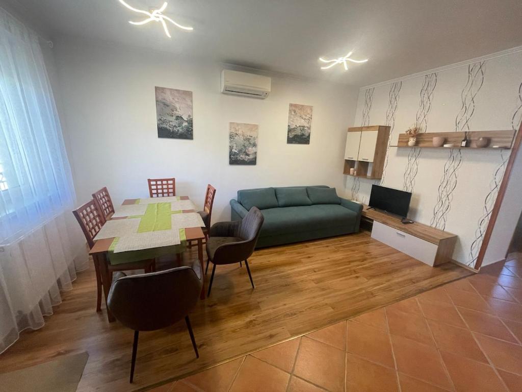 a living room with a table and a green couch at Kosbor apartman in Igricetanya