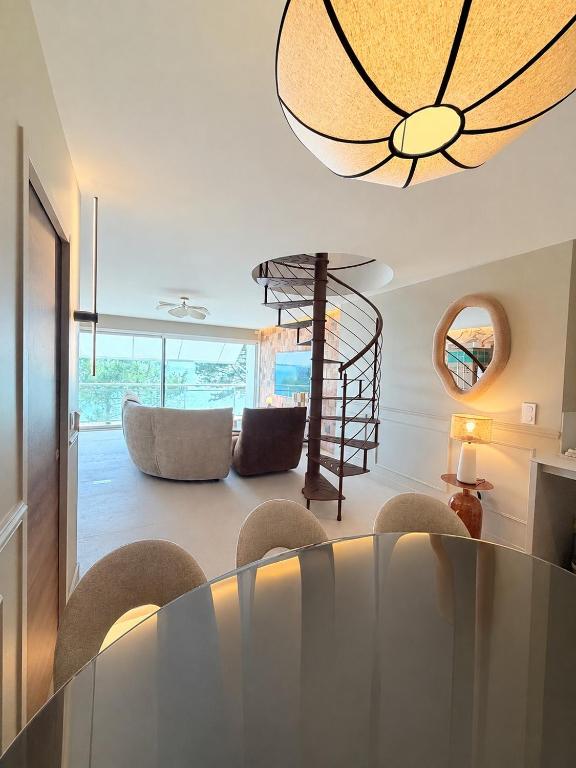a living room with a dining table and a chandelier at Escale élégante à la mer Duplex neuf en front de mer in Bénodet