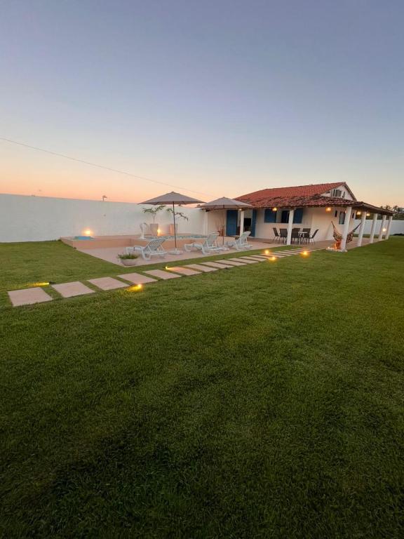 a house with a large lawn in front of the water at Califeira do Patacho in Pôrto de Pedras