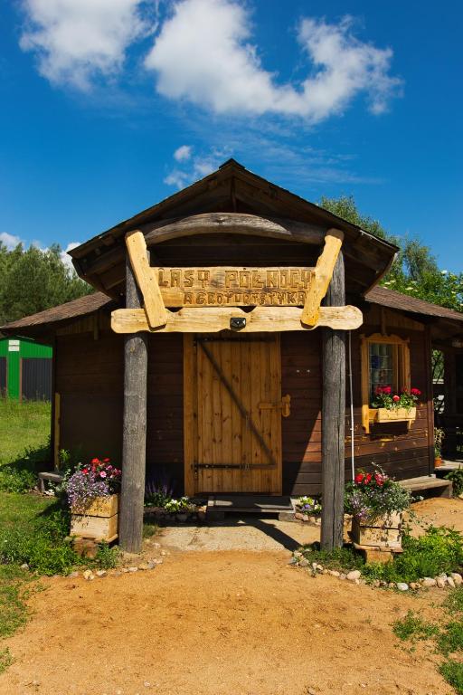 a wooden sign in front of a small building at Agroturystyka Lasy Północy Leśna Chata in Dzierniakowo