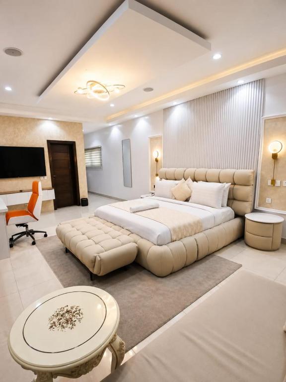 a large bedroom with a large bed and a desk at NO 5 Hotel in Lekki