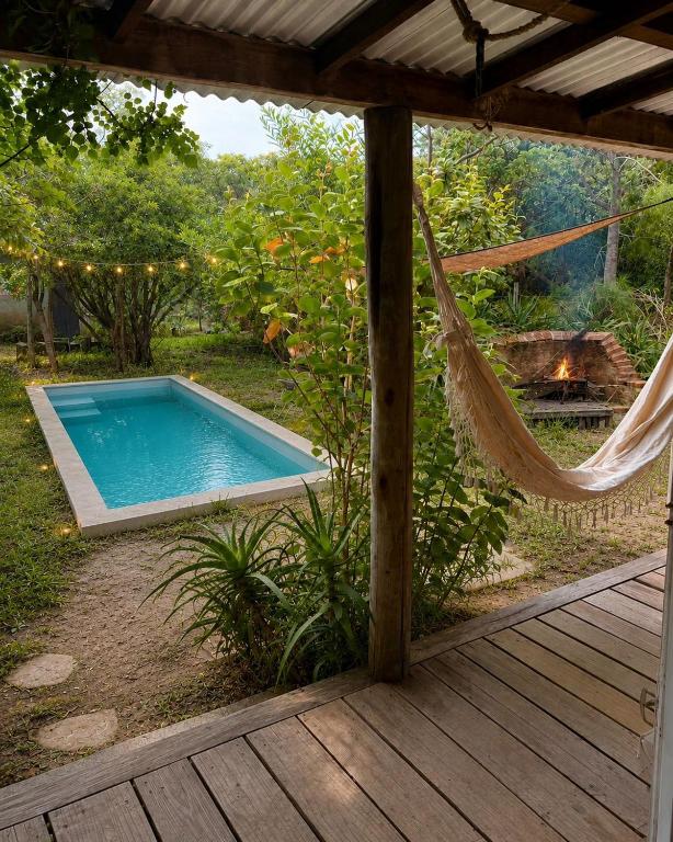 a hammock on a deck next to a swimming pool at Posada Hale Nalu in La Paloma