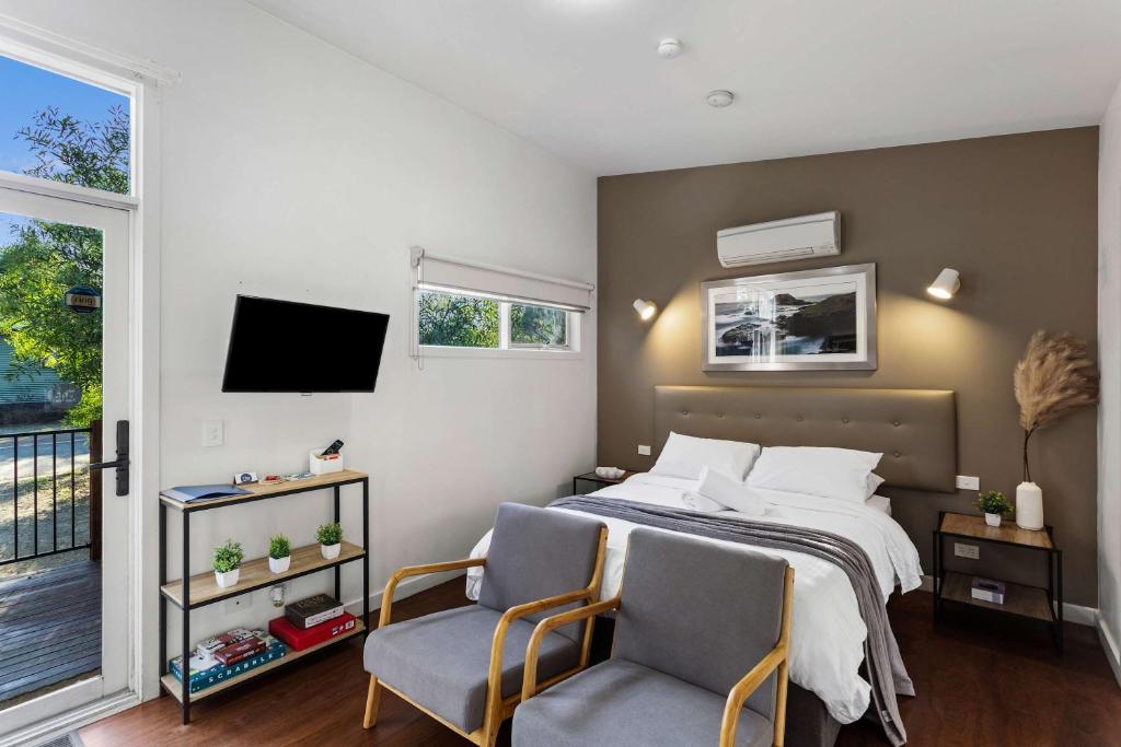 a bedroom with a bed and two chairs at The Point Villa in Cowes