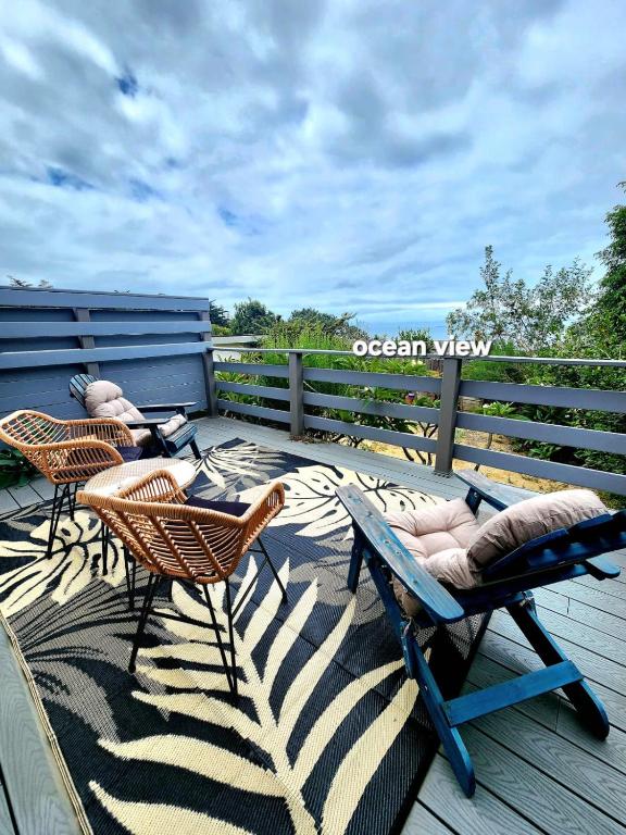 three chairs and a table on a deck at 30 PCT OFF!! Limited Time! Malibu Ocean Wave with King Bed, Walking to Beach and Hiking in Malibu