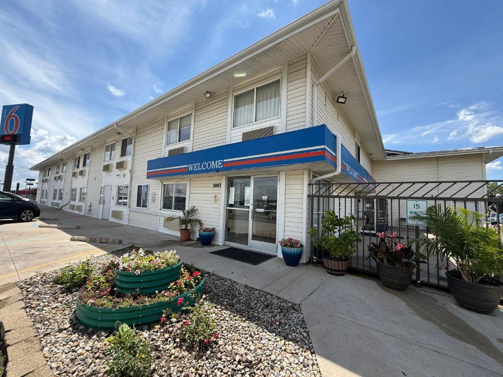 a hotel building with plants in front of it at Motel 6-Fort Wayne, IN in Fort Wayne