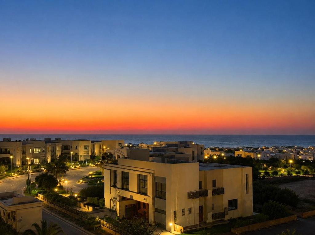 a view of a city at sunset with a building at GAIA Penthouse in El Dab‘a