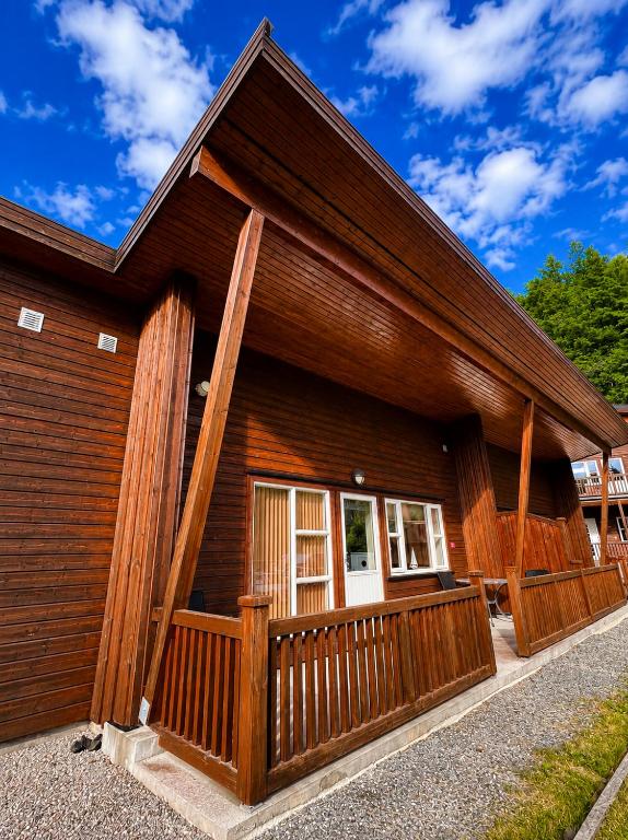 a large wooden building with a porch at Olavsberget camping in Porsgrunn