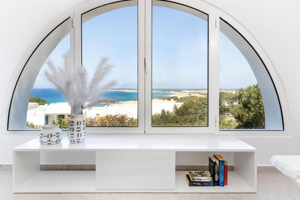 a room with a large window with a white table at Pyrgaki Hideout Beachfront Apartment in Agiassos
