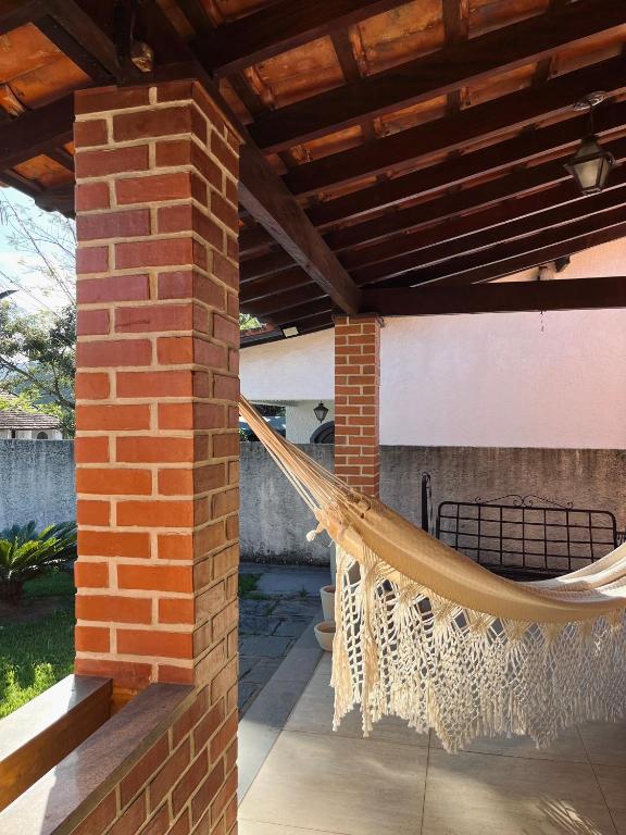 a hammock on the patio of a house at Encanto da Serra casa 1 in Miguel Pereira