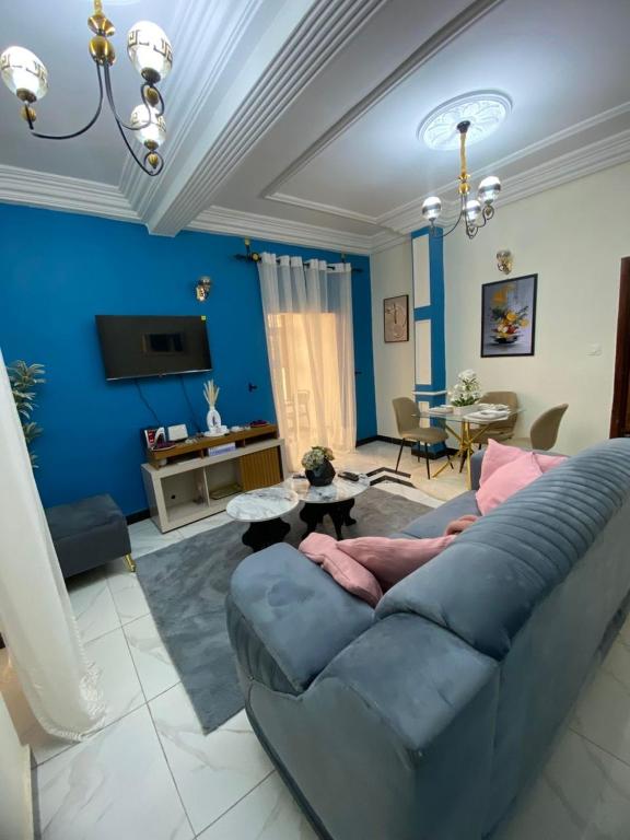 a living room with a couch and a blue wall at Lita Residence in Yaoundé
