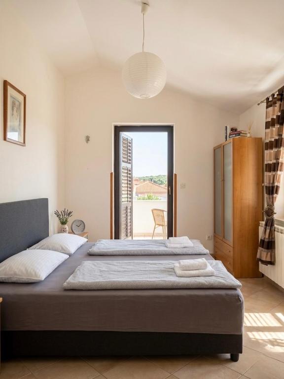 a bedroom with a large bed and a window at Danilo Room in Pula