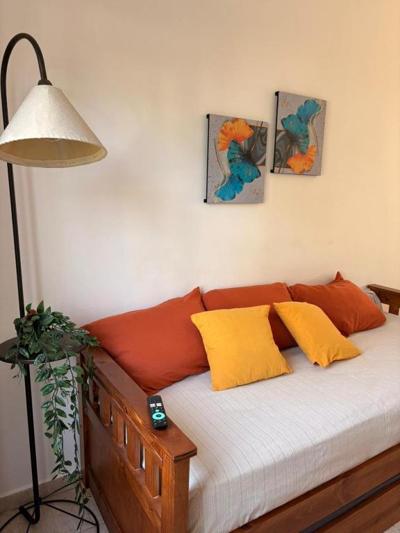 a bed with orange and yellow pillows in a room at Los Aromos Sinsacate in Sinsacate