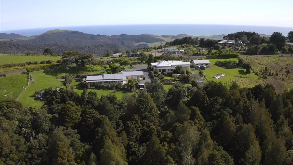 an aerial view of a house on a hill with trees at Waipoua Lodge in Aranga
