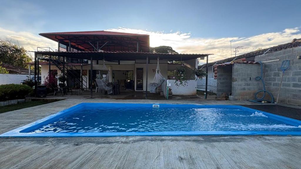a large blue swimming pool in front of a house at Finca San Barbara in Pavas
