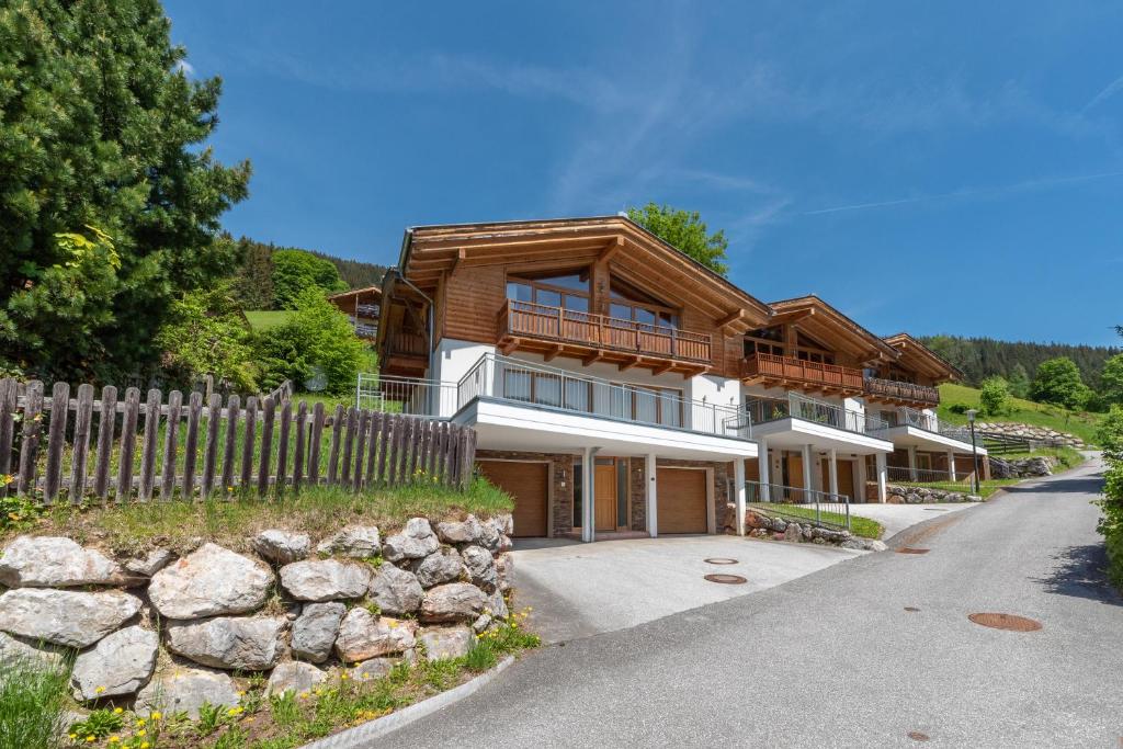 a large wooden house with a wooden fence at Ski Chalet Jim by All in One Apartments in Zell am See
