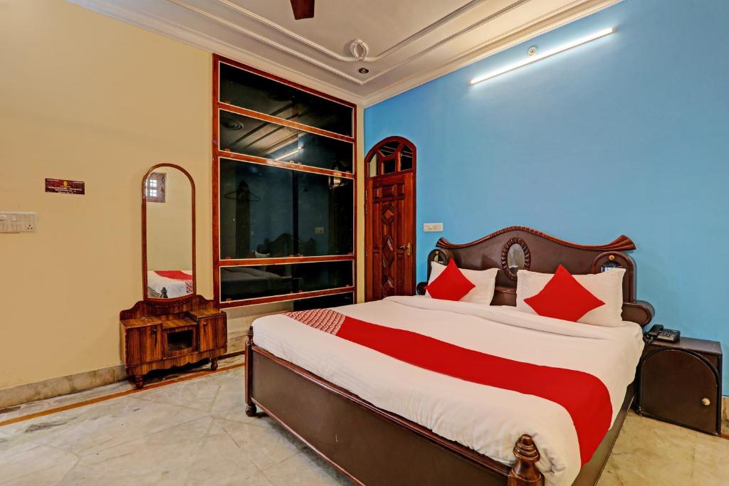 a bedroom with a large bed with red pillows at Hotel O Shiva Grand in Chinhat
