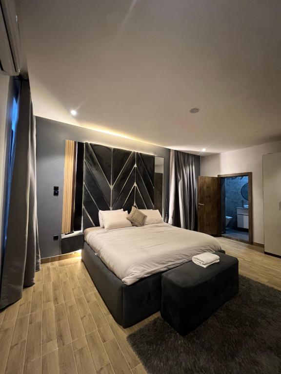 a bedroom with a large bed with a large headboard at Bgold home Apartment in Lekki