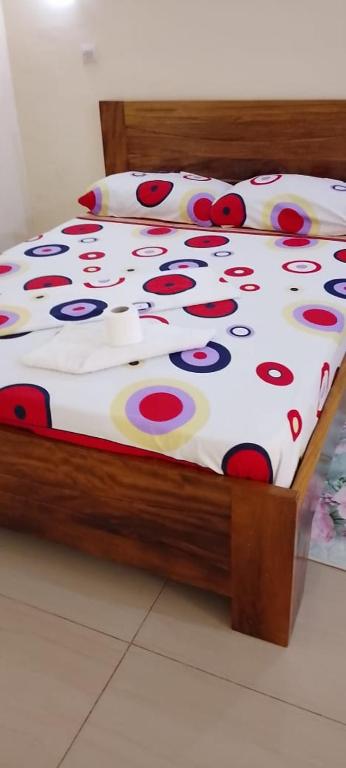 a bed with red and yellow flowers on it at Residence samy in San-Pédro