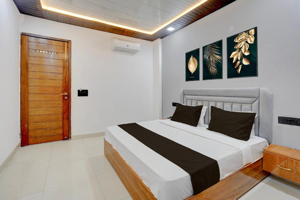 a bedroom with a bed and a wooden door at Townhouse Tuessday Suites Nearst Mr Bhatura Bala Sector 122 in Noida