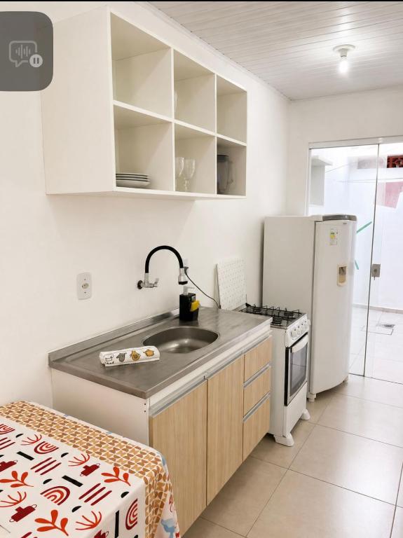 a kitchen with a sink and a refrigerator at Casa próximo a Dutra- Excelente Localização in Lorena