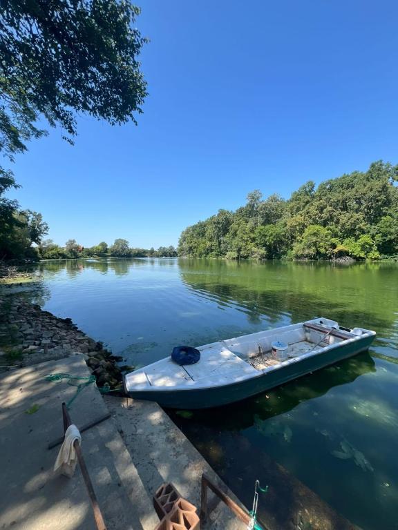 a boat is docked at a dock on a river at River House Batrovci in Batrovci