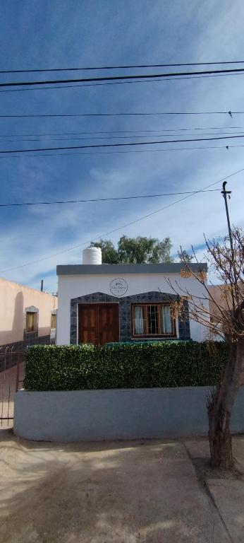 a white house with a hedge in front of it at Alojamiento DON ANTONIO in Tinogasta