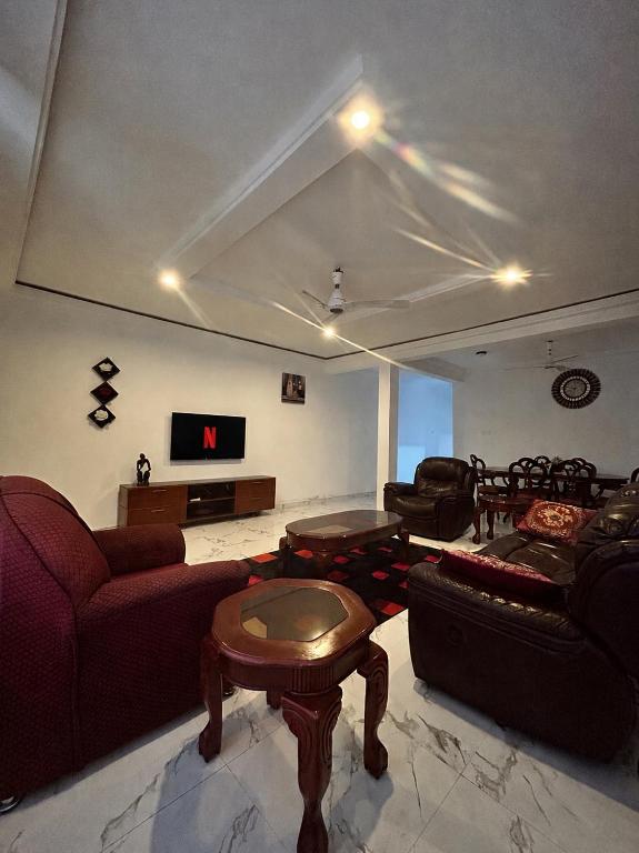 ein großes Wohnzimmer mit Sofas und einem Fernseher in der Unterkunft Vip holiday inn in Aiyimensa