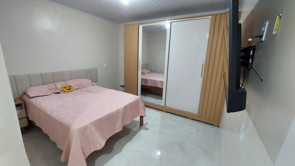 a bedroom with a pink bed and a mirror at Apartamento próximo ao Bumbódromo in Parintins