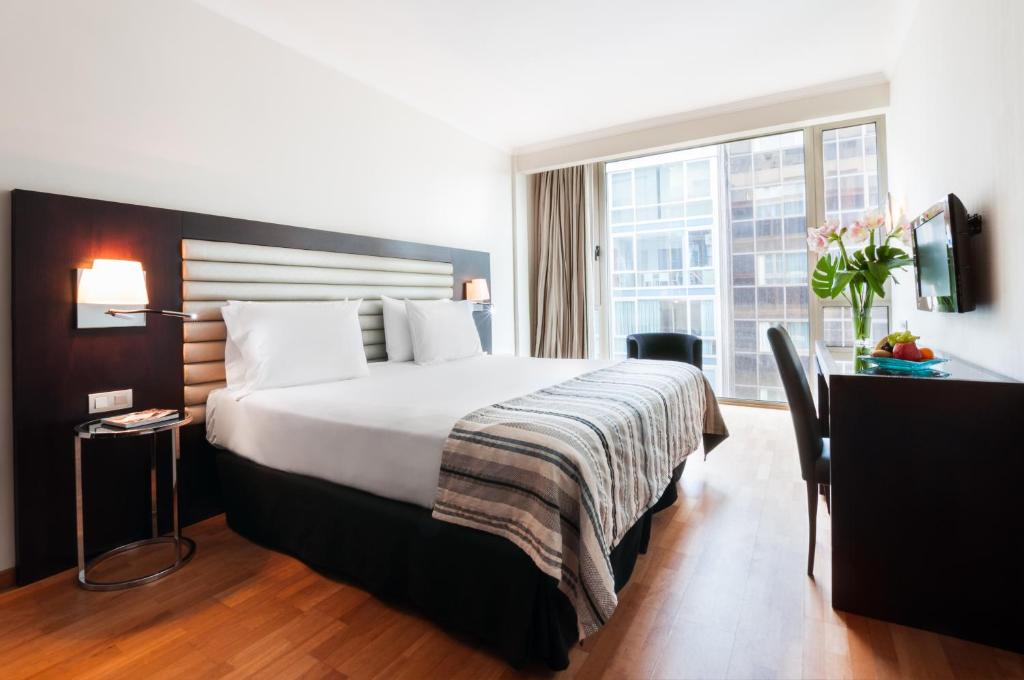 a hotel room with a large bed and a window at Exe Cristal Palace in Barcelona