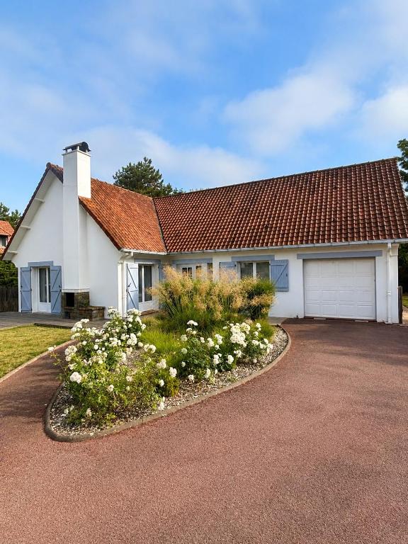 a white house with a red roof and a driveway at Maison chaleureuse proche plage et forêt in Neufchâtel-Hardelot
